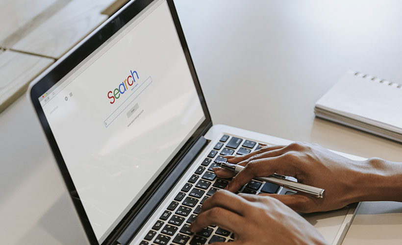 User entering a search on a laptop using paid search marketing WebCie