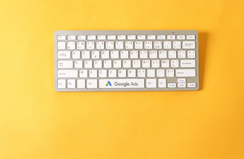 White keyboard over yellow background with dedicated Google Ads button used by Google Ads Agency WebCie