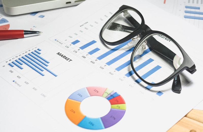 Glasses and charts on desk by Google Ads Agency in Montréal WebCie Inc.