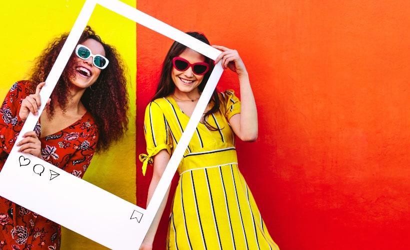 content-strategy-social-media-instagram-facebook Two women holding up a picture frame. Facebook and Instagram management.